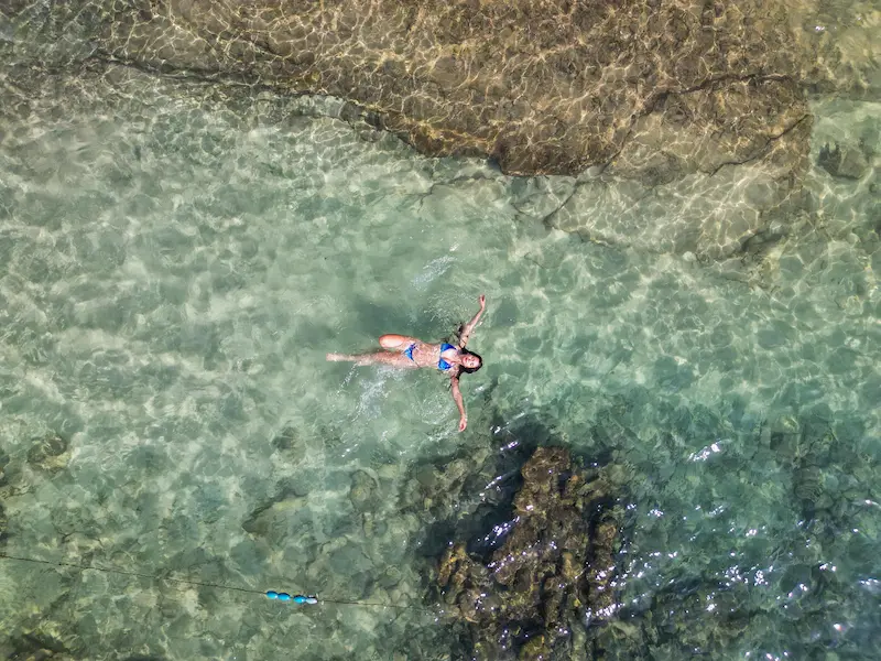 Mujer flotando en aguas cristalinas del Parque Tayrona