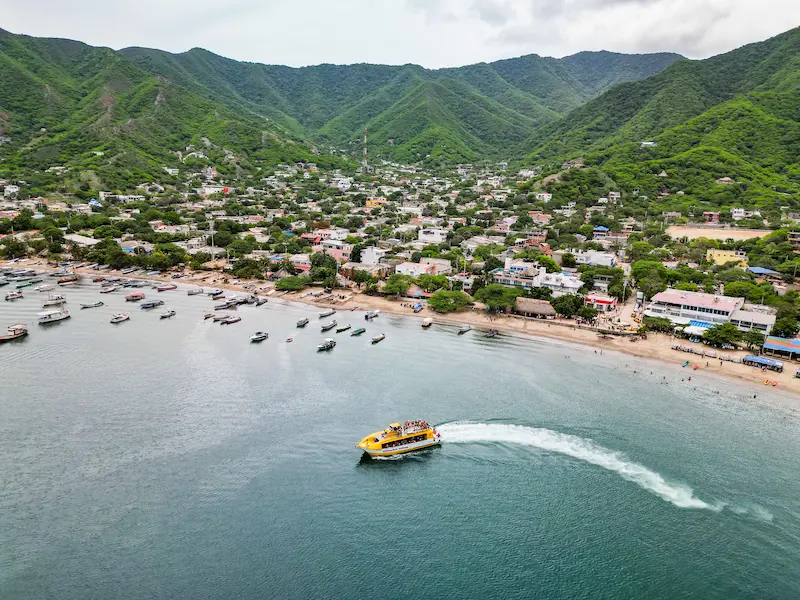Vista aérea de Taganga con catamarán turístico